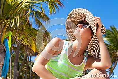 Woman under palm tree at beach