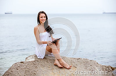 Woman use touch pad tablet pc internet technology sitting beach
