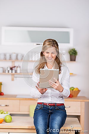 Woman Using Digital Tablet In Kitchen