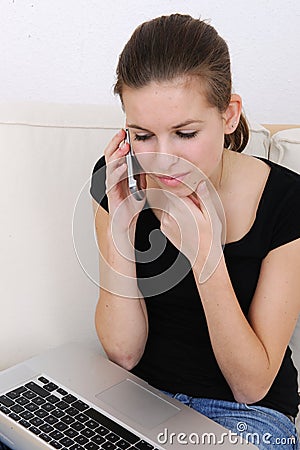 Woman using a laptop and talking on phone