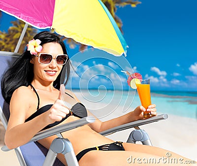 Woman on vacation at beach with thumbs up sign