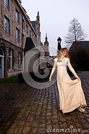 Woman in Victorian dress, old city square, evening