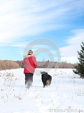 Woman walking with dog in snow