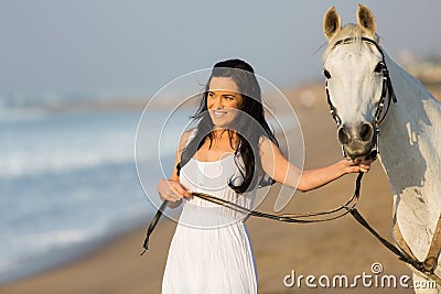 Woman walking horse beach