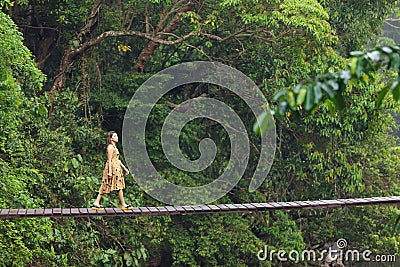Woman walking on jungle bridge