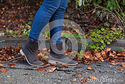 Woman walking on a street full of leaves during Autumn