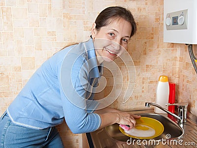 The woman washes ware on kitchen