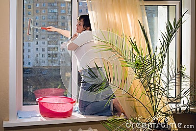 A woman washes a window