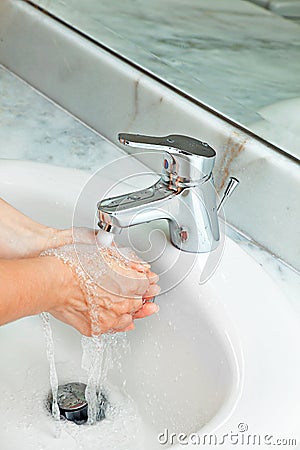 Woman washing hands at modern marble bathroom