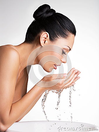 Woman washing her clean face with water