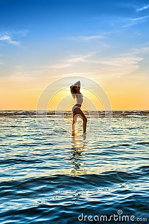 Woman in white bikini posing in a sea