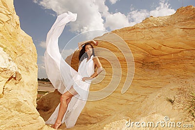 Woman in white dress dancing on the desert