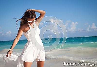 Woman in a white dress on the ocean coast