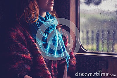 Woman by window in old train carriage