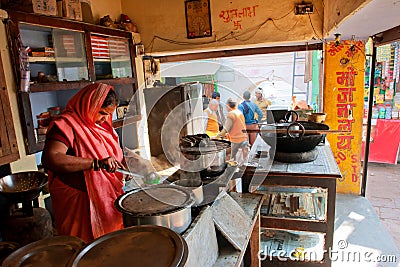 Woman woman cooks food in an outdoor cafe