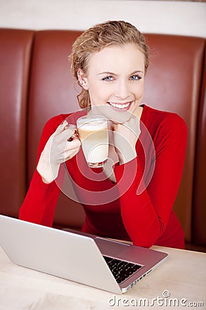 Woman working with laptop while having coffee break