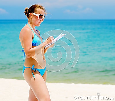 Young woman with notebook on a beach