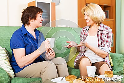 Women colleagues drinking tea and chatting during coffee break