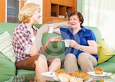 Women colleagues drinking tea and talking during pause for lunch