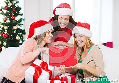 Women in santa helper hats with card and gifts
