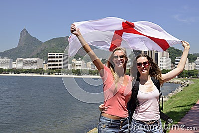 Women sport fans holding the England flag in Rio de Janeiro.ound.