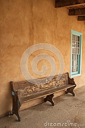 Wood bench beside teal trimmed window