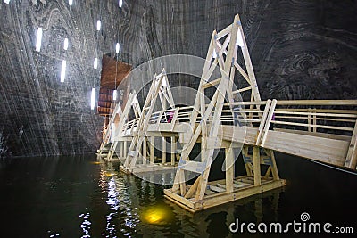 Wood bridge over underground lake in Turda Salt Mine