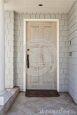 Wood front door of home with raw finish in daytime