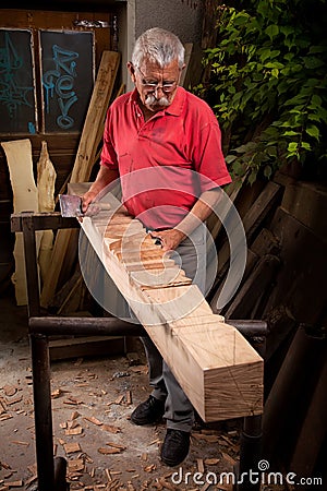 Woodcarver working with mallet and chisel