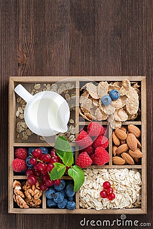 Wooden box with breakfast items - oatmeal, granola, nuts, berry