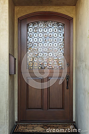 Wooden front door of home with ornate glass detail