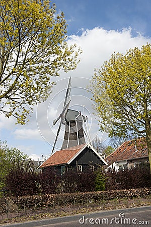 Wooden wind mill in a farm scenery