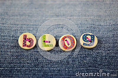 The word blog spelled in lettered buttons on denim