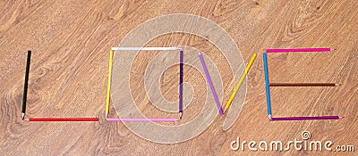 Word love made by colorful pencils on table