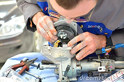 Automotive worker repair a steering wheel column