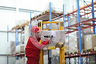 Worker with bar code reader working in warehouse