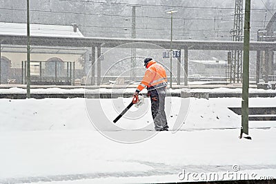 Worker is cleaning the platform of a train station