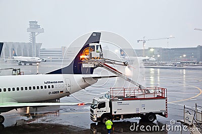 Worker deices the wing of the plain