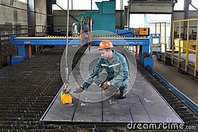 Worker fixes Magnetic lifters lift plane of steel sheet.