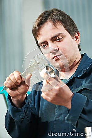 Worker measuring detail with caliper