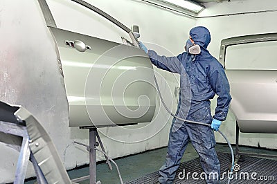 Worker painting car door.