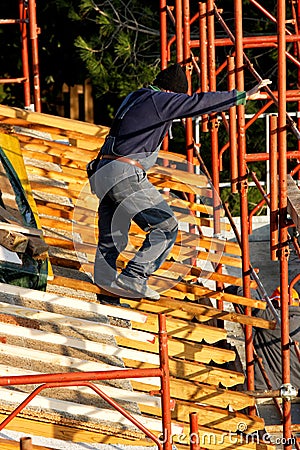 Worker on the roof, house under construction