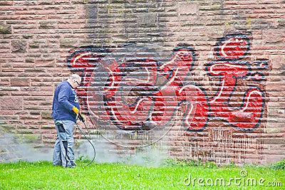 A worker washes a wall