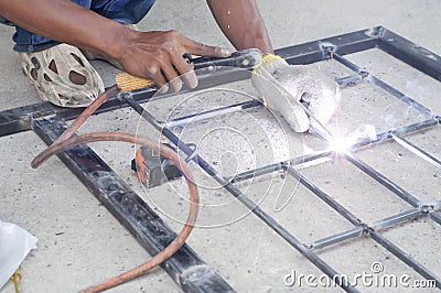 Worker welding steel bars.