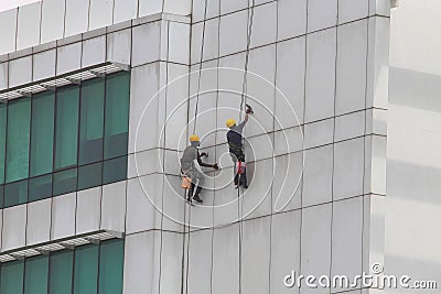 Workers cleaning or painting a multistory building