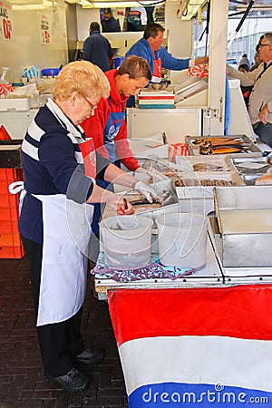 Workers cut up fish for sale at a market in Dordrecht,