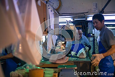 Workers processing Tuna at Tsukiji market in Japan