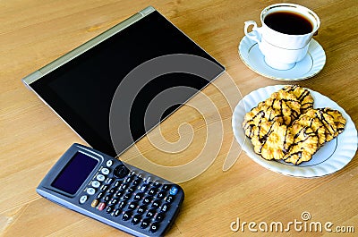 Workplace with tablet pc, calculator, cup of coffee and cookies