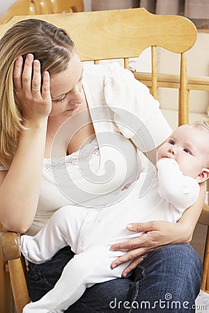 Worried Mother Holding Baby In Nursery