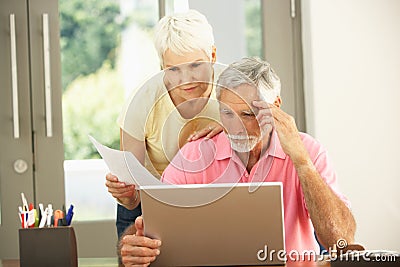 Worried Senior Couple Using Laptop At Home